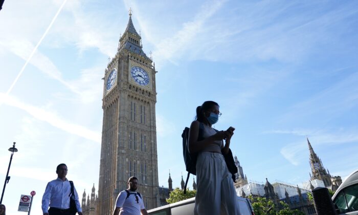 People walk past Big Ben at the Houses of Parliament in London, on July 15, 2022. (Dominic Lipinski/PA Media)