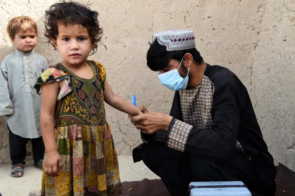 A health worker marks a child's finger with ink after giving polio vaccine at a campaign in Kandahar, Afghanistan, on June 28, 2022. (Javed Tanveer/AFP/Getty Images)