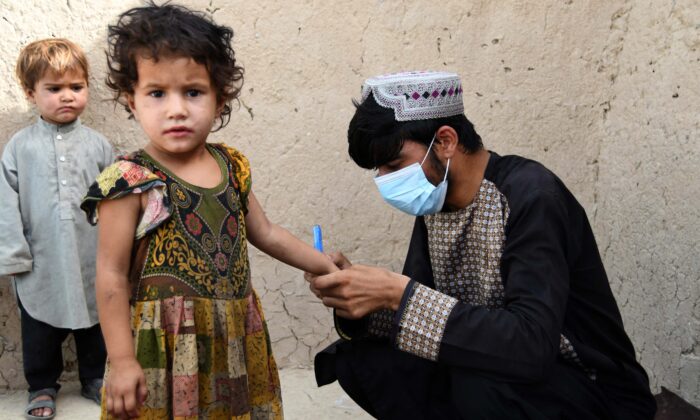 A health worker marks a child's finger with ink after giving polio vaccine at a campaign in Kandahar, Afghanistan, on June 28, 2022. (Javed Tanveer/AFP/Getty Images)