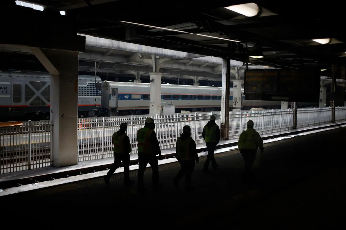 Workers walk past an Amtrak train along the platform at Chicago Union Station in Chicago on March 2, 2022. (Luke Sharrett/AFP via Getty Images)