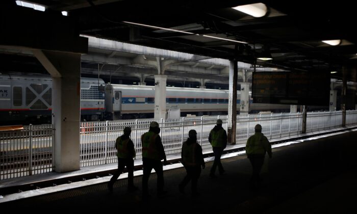 Workers walk past an Amtrak train along the platform at Chicago Union Station in Chicago on March 2, 2022. (Luke Sharrett/AFP via Getty Images)