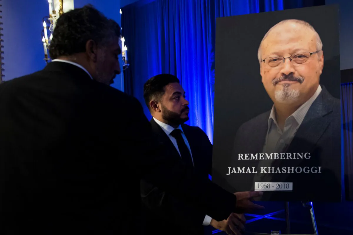 "Justice For Jamal" Campaign leader Ahmed Bedier (C) adjust the portrait of late Washington Post journalist Jamal Khashoggi during a remembrance ceremony for him in Washington on Nov. 2, 2018. (Jim Watson/AFP via Getty Images)
