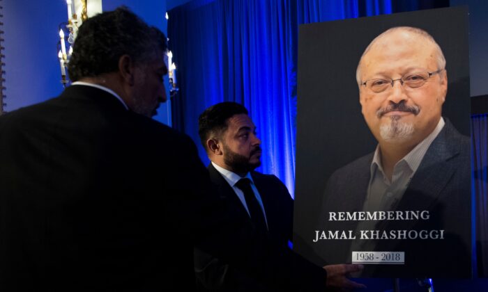 "Justice For Jamal" Campaign leader Ahmed Bedier (C) adjust the portrait of late Washington Post journalist Jamal Khashoggi during a remembrance ceremony for him in Washington on Nov. 2, 2018. (Jim Watson/AFP via Getty Images)