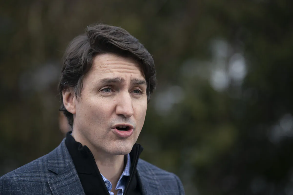 Prime Minister Justin Trudeau speaks about Budget 2022 highlights on housing investments from a podium in a family home's backyard in Hamilton, Ontario, on April 8, 2022. (Peter Power/The Canadian Press)