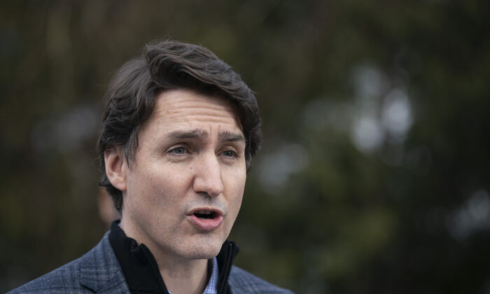 Prime Minister Justin Trudeau speaks about Budget 2022 highlights on housing investments from a podium in a family home's backyard in Hamilton, Ontario, on April 8, 2022. (Peter Power/The Canadian Press)