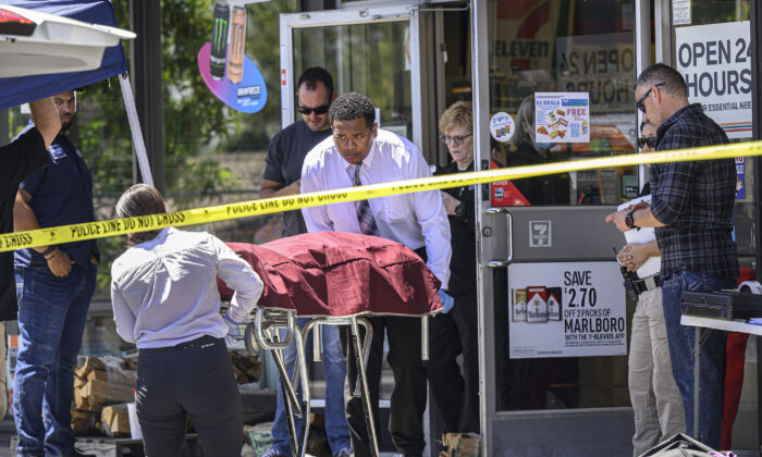 Authorities remove a body from a 7-Eleven after a clerk was fatally shot during a robbery in Brea, Calif., on July 11, 2022. (Mindy Schauer/The Orange County Register via AP)