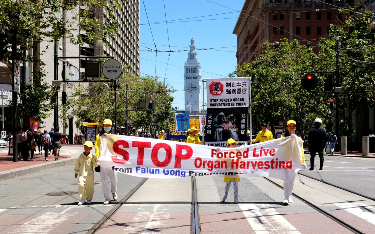 Falun Gong adherents hold a banner demanding an end to involuntary organ-harvesting during a parade in San Francisco on July 16, 2022. (David Lam/The Epoch Times)