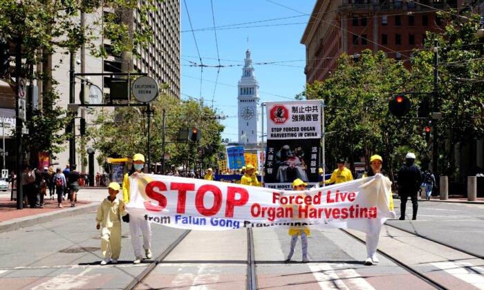 Falun Gong adherents hold a banner demanding an end to involuntary organ-harvesting during a parade in San Francisco on July 16, 2022. (David Lam/The Epoch Times)