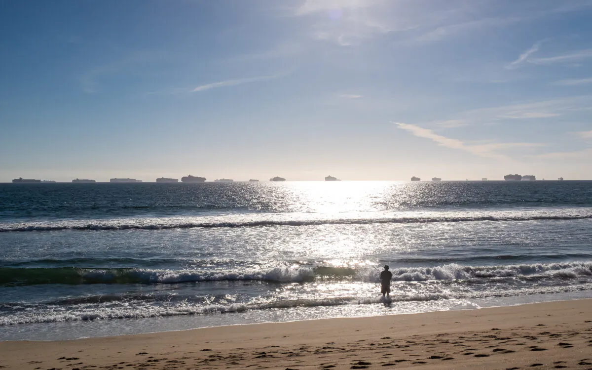 A man looks into the water of Sunset Beach in Huntington Beach, Calif., on Oct. 24, 2021. (John Fredricks/The Epoch Times)