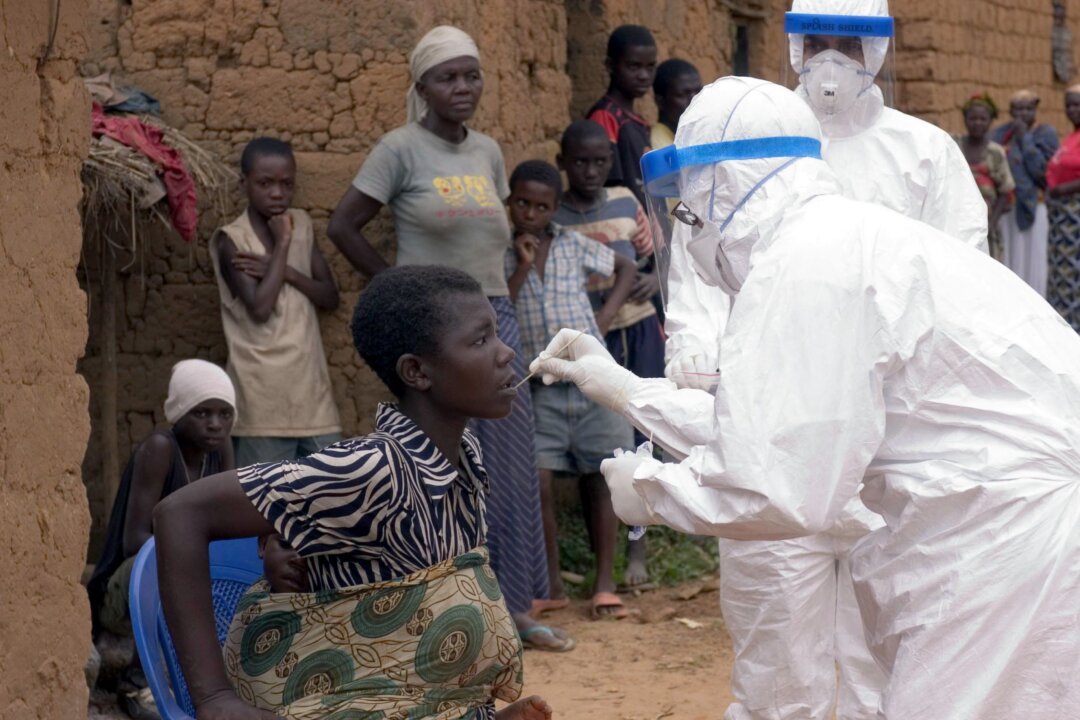 Doctor Mark Katz, a member of the World Health Organisation (WHO), takes an oral sample from patient Feliciana suspected of having Marburg haemorrhagic fever in Kinguangua, near Uige, on May 6, 2005.(Christopher Black/WHO/AFP via Getty Images)