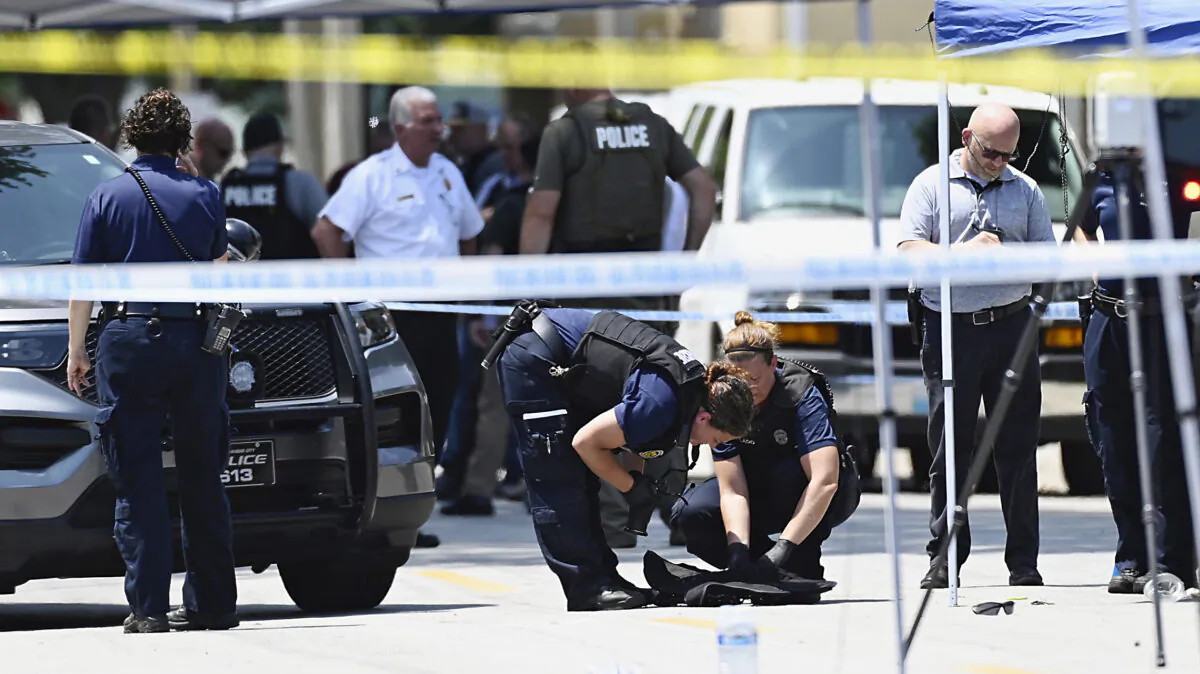 Law enforcement officers look over the protective vest that North Kansas City Police Officer Daniel Vasquez was wearing when he was fatally shot during a traffic stop, in North Kansas City, Mo., on July 19, 2022. (Tammy Ljungblad/The Kansas City Star via AP)