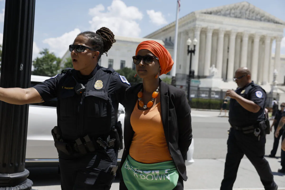 Rep. Ilhan Omar (D-Minn,) is detained by U.S. Capitol Police Officers after participating in a sit in with activists from Center for Popular Democracy Action (CPDA) in front of the U.S. Supreme Court Building in Washington on July 19, 2022. (Anna Moneymaker/Getty Images)