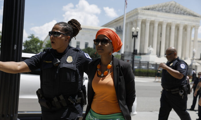 Rep. Ilhan Omar (D-Minn,) is detained by U.S. Capitol Police Officers after participating in a sit in with activists from Center for Popular Democracy Action (CPDA) in front of the U.S. Supreme Court Building in Washington on July 19, 2022. (Anna Moneymaker/Getty Images)