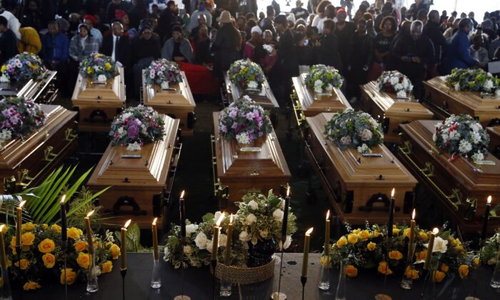 Coffins of 21 teenagers who died in a mysterious tragedy at a nightclub in the early hours of June 26, 2022 are lined up during their funeral held in Scenery Park, East London, South Africa, on July 6, 2022. (AP Photo)