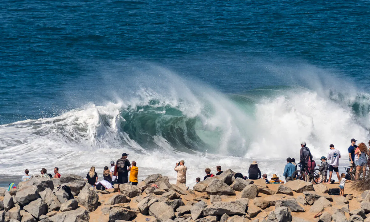Beachgoers watch body surfers, surfers, and body boarders attempt to ride an 8-12 foot day at The Wedge in Newport Beach, Calif., on July 19, 2022. (John Fredricks/The Epoch Times)
