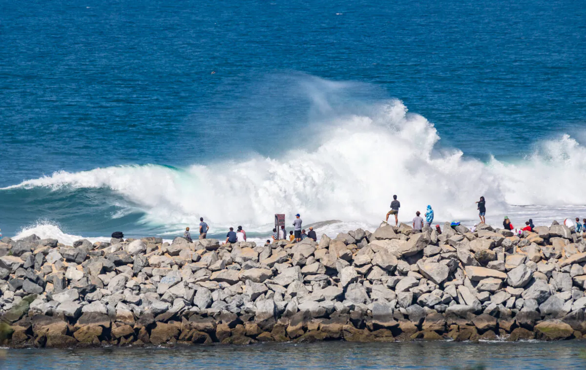 Beachgoers watch body surfers, surfers, and body boarders attempt to ride an 8-12 foot day at The Wedge in Newport Beach, Calif., on July 19, 2022. (John Fredricks/The Epoch Times)