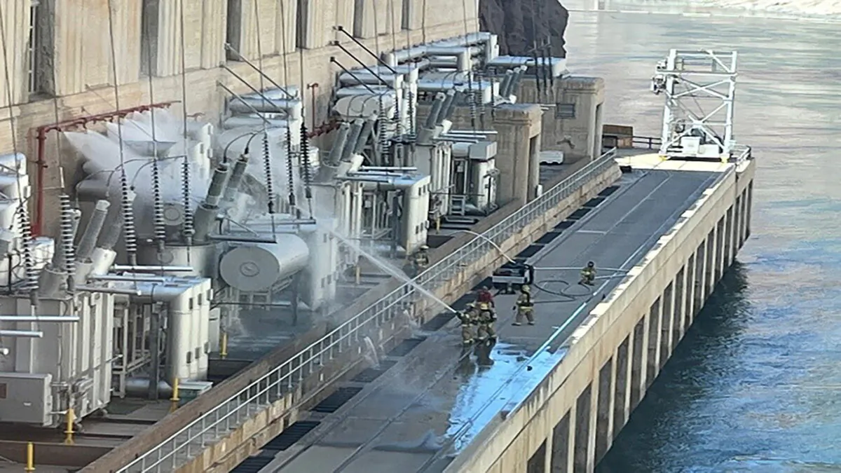 Firefighters pour water on electrical transformer equipment at the Hoover Dam near Boulder City, Nev., on July 19, 2022 in a still image from video. (Bureau of Reclamation/Handout via Reuters)