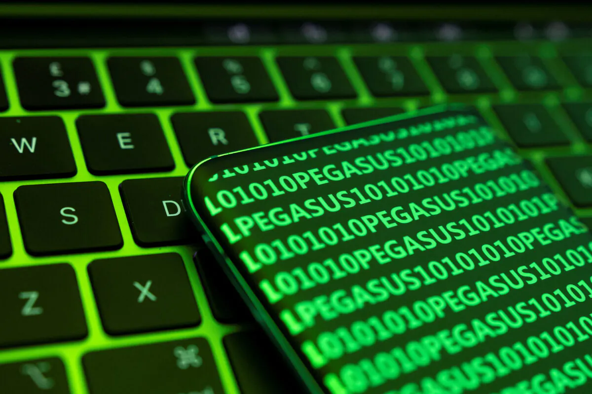 The word Pegasus and binary code are displayed on a smartphone which is placed on a keyboard in this illustration taken May 4, 2022. (Dado Ruvic/Reuters)