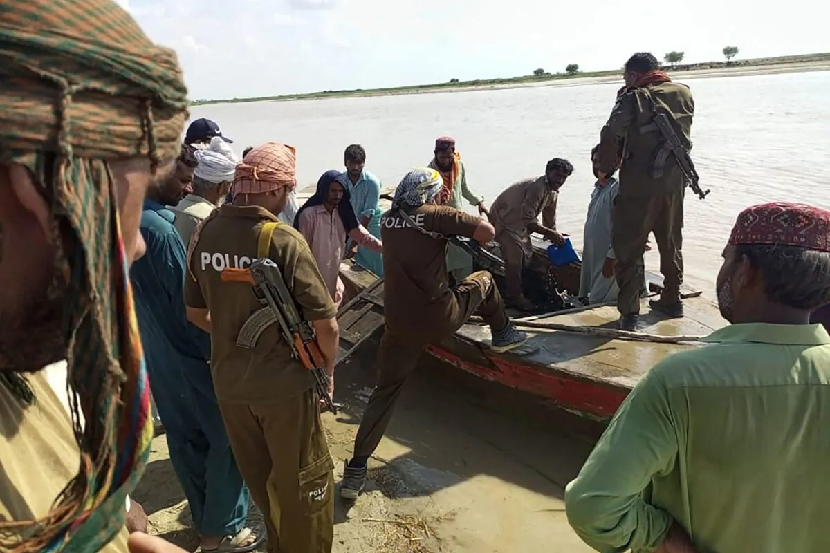 Policemen and local villagers prepare to search for the victims drowned at Indus River after an overcrowded boat carrying a Pakistan wedding party capsized on the outskirt of Sadiqabad town on July 18, 2022. (AFP via Getty Images)