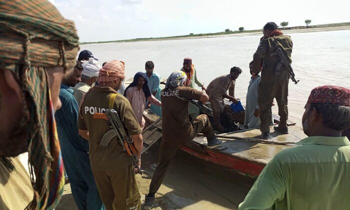 Policemen and local villagers prepare to search for the victims drowned at Indus River after an overcrowded boat carrying a Pakistan wedding party capsized on the outskirt of Sadiqabad town on July 18, 2022. (AFP via Getty Images)