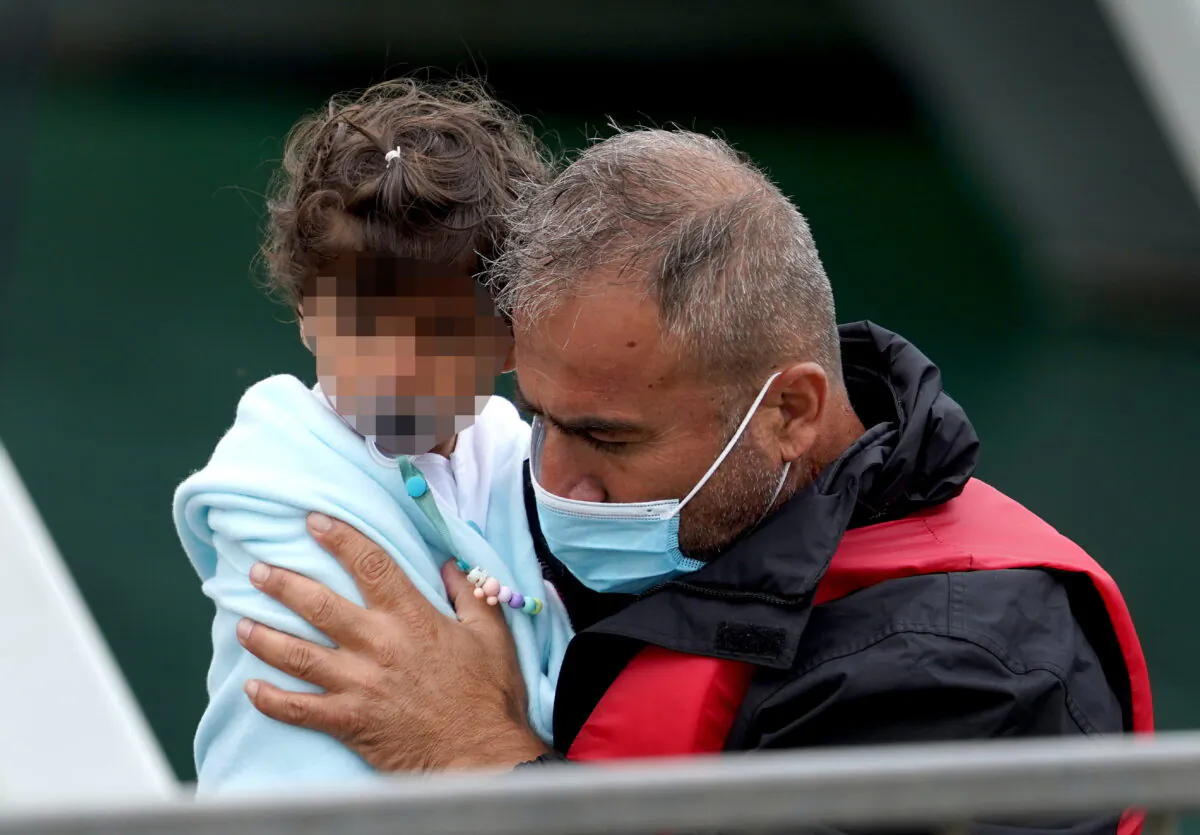Undated image of a child being brought ashore at Dover. (Gareth Fuller/PA)