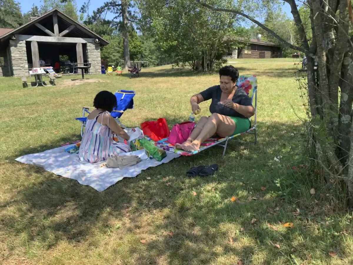 Rosa Chavez of New York applies sunscreen as she and friend Arlene Rodriguez visit Promised Land State Park in Pennsylvania's Pocono Mountains on July 24, 2022. (Jeff McMillan/AP Photo)