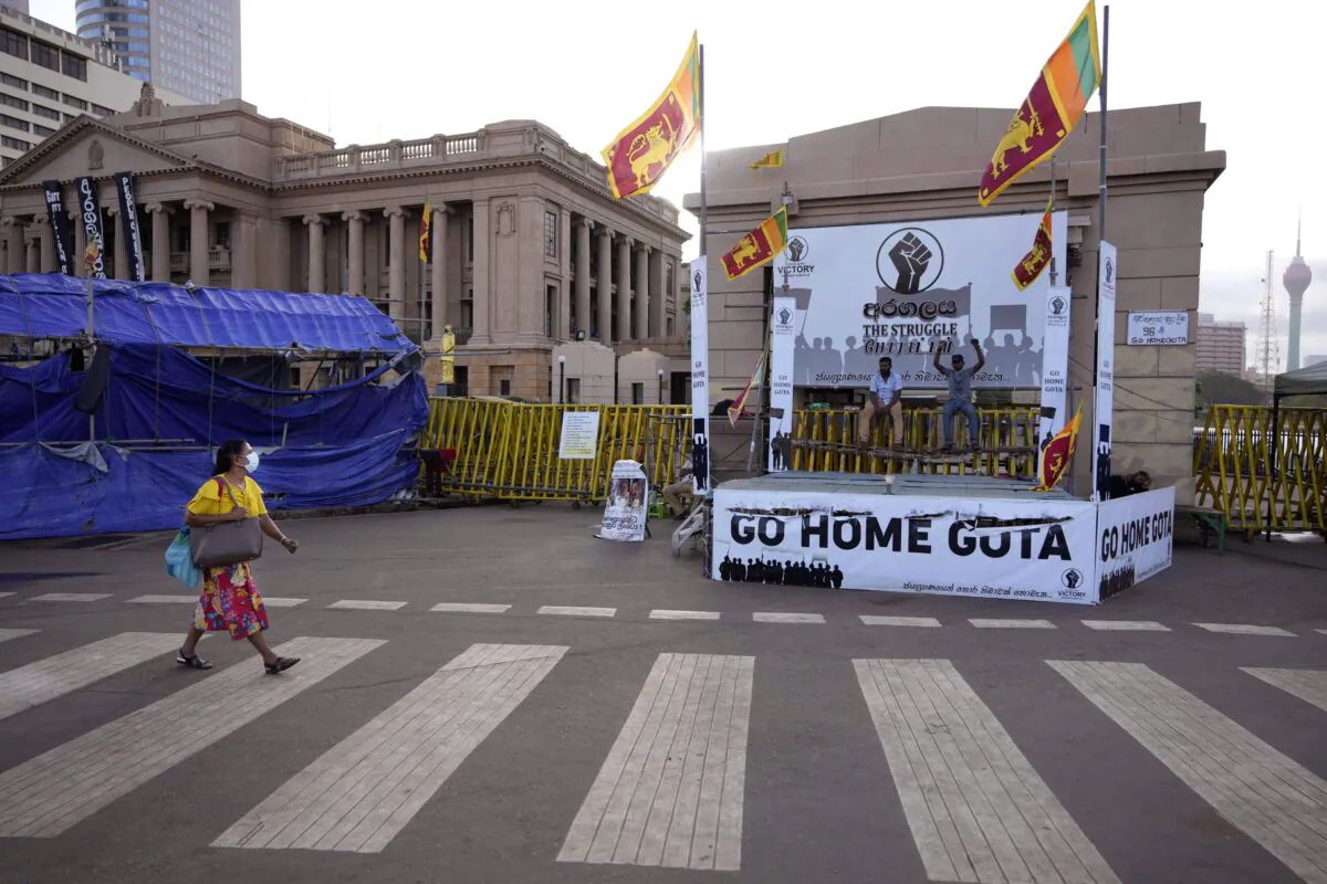 A woman walks past protesters blocking the entrance to the presidential secretariat in Colombo, Sri Lanka, on July 15, 2022. (Eranga Jayawardena/AP Photo)