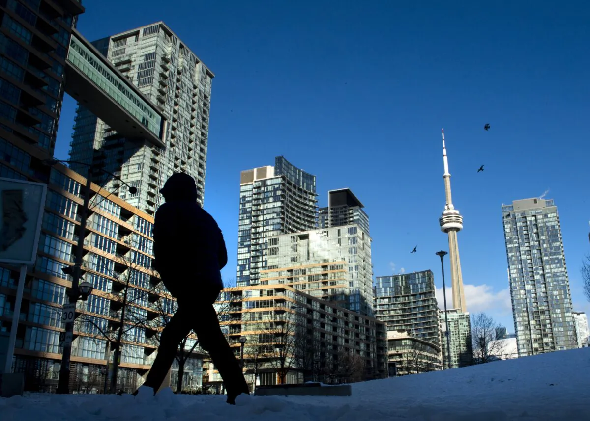 Condo towers dot the Toronto skyline as a pedestrian makes his way through the winter landscape on Jan. 28, 2021. (Frank Gunn/The Canadian Press)