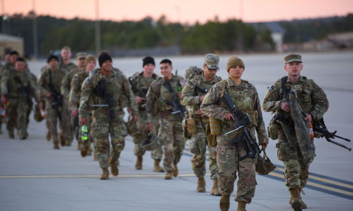 Soldiers with the 82nd Airborne division walk across the tarmac at Green Ramp to deploy to Poland at Fort Bragg, Fayetteville, North Carolina, on Feb. 14, 2022. (Melissa Sue Gerrits/Getty Images)