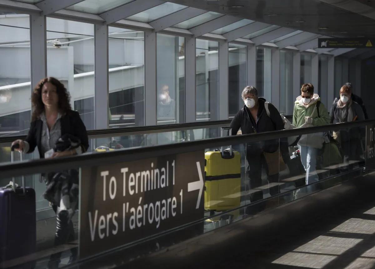 People leave after arriving at Pearson International Airport in Toronto on March 16, 2020. (The Canadian Press/Nathan Denette)