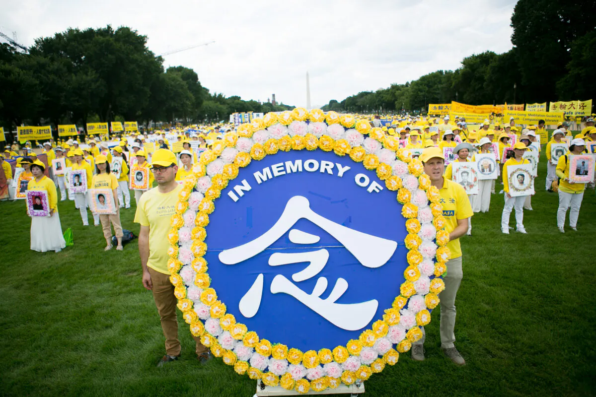 Falun Gong practitioners hold wreaths in memory of victims of the Chinese regime's persecution of Falun Gong, in the National Mall, Washington, on July 21, 2022. (Lisa Fan/The Epoch Times)
