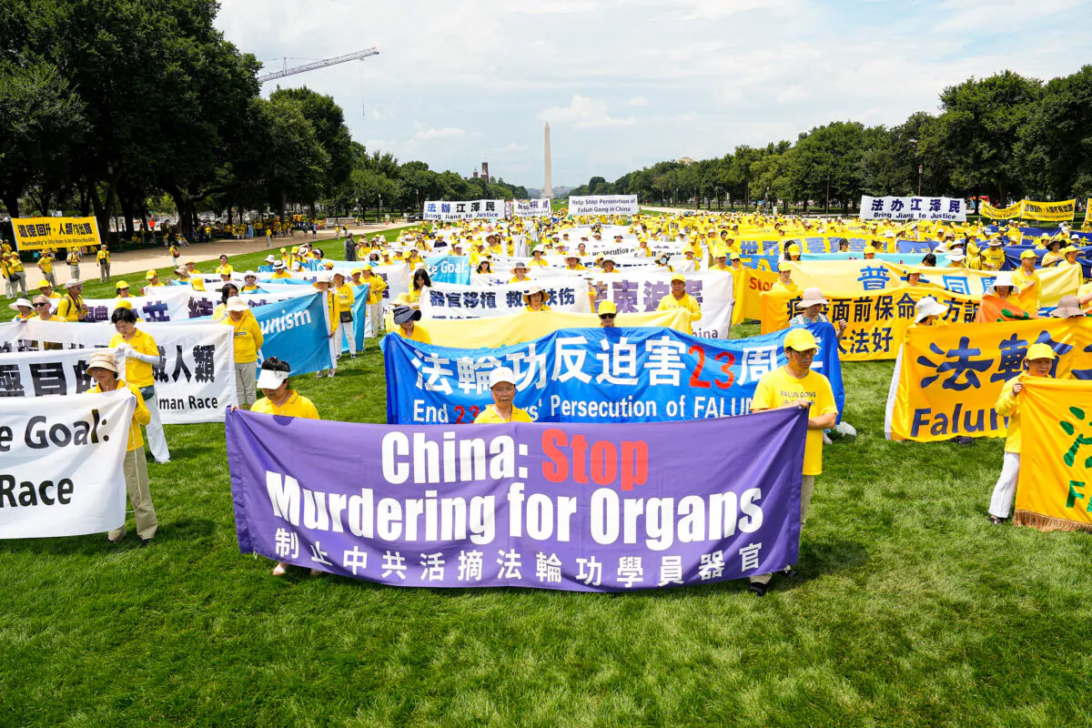 Falun Gong practitioners take part in a rally to commemorate the 23rd anniversary of the launch of the Chinese regime's persecution of spiritual group Falun Gong, on the National Mall in Washington on July 21, 2022. (Larry Dye/The Epoch Times)
