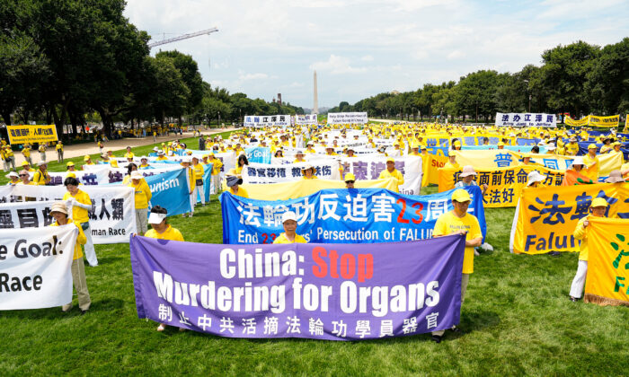 Falun Gong practitioners take part in a rally to commemorate the 23rd anniversary of the launch of the Chinese regime's persecution of spiritual group Falun Gong, on the National Mall in Washington on July 21, 2022. (Larry Dye/The Epoch Times)