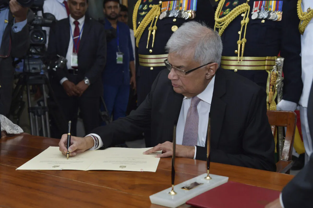 Sri Lanka's newly elected president Ranil Wickremesinghe, signs after taking oath during his swearing in ceremony in Colombo, Sri Lanka, on July 21, 2022. (Sri Lankan President's Office via AP)