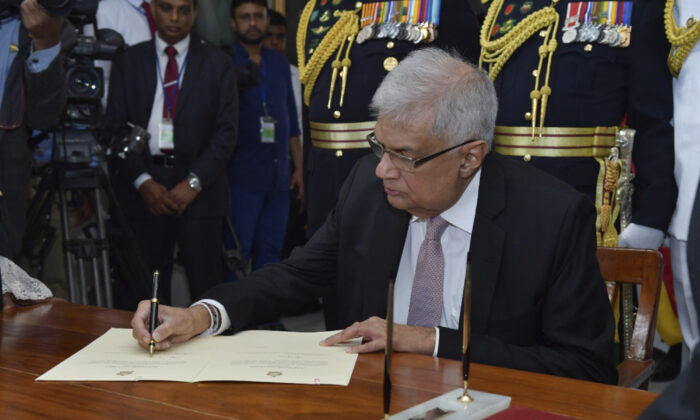 Sri Lanka's newly elected president Ranil Wickremesinghe, signs after taking oath during his swearing in ceremony in Colombo, Sri Lanka, on July 21, 2022. (Sri Lankan President's Office via AP)