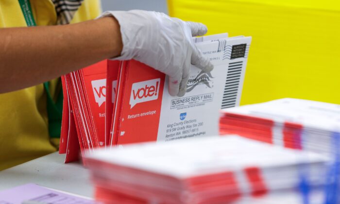 An election worker opens envelopes containing vote-by-mail ballots for the August 4 Washington state primary at King County Elections in Renton, Washington on Aug. 3, 2020. (Jason Redmond/AFP via Getty Images)