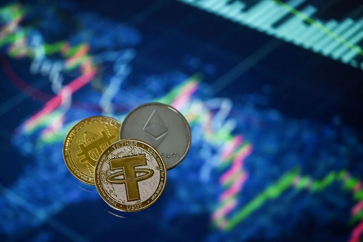 An illustration picture shows gold plated souvenir cryptocurrency Tether (USDT), Bitcoin, and Ethereum coins arranged beside a screen displaying a trading chart, in London on May 8, 2022. (Justin Tallis/AFP via Getty Images)