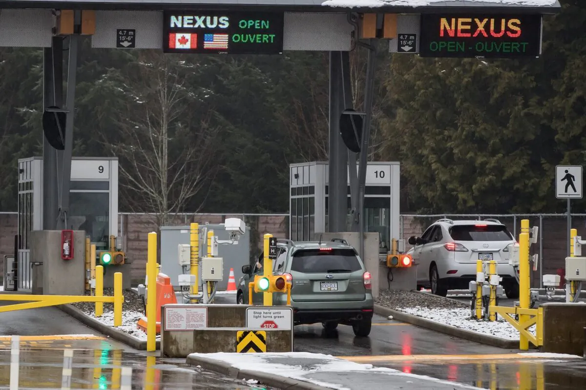 A motorist scans a Nexus card as another speaks with a Canada Border Services Agency officer at a primary inspection booth at the Douglas-Peace Arch border crossing in Surrey, B.C., on Feb. 5, 2020. (The Canadian Press/Darryl Dyck)