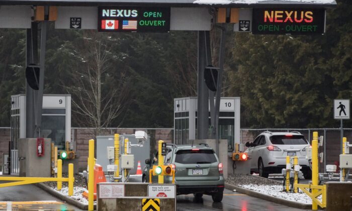 2020 年 2 月 5 日，在不列颠哥伦比亚省萨里市道格拉斯-和平拱门过境点的主要检查站，一名驾车者扫描 Nexus 卡，另一名驾车者与加拿大边境服务局官员交谈。（加拿大新闻社/Darryl Dyck）