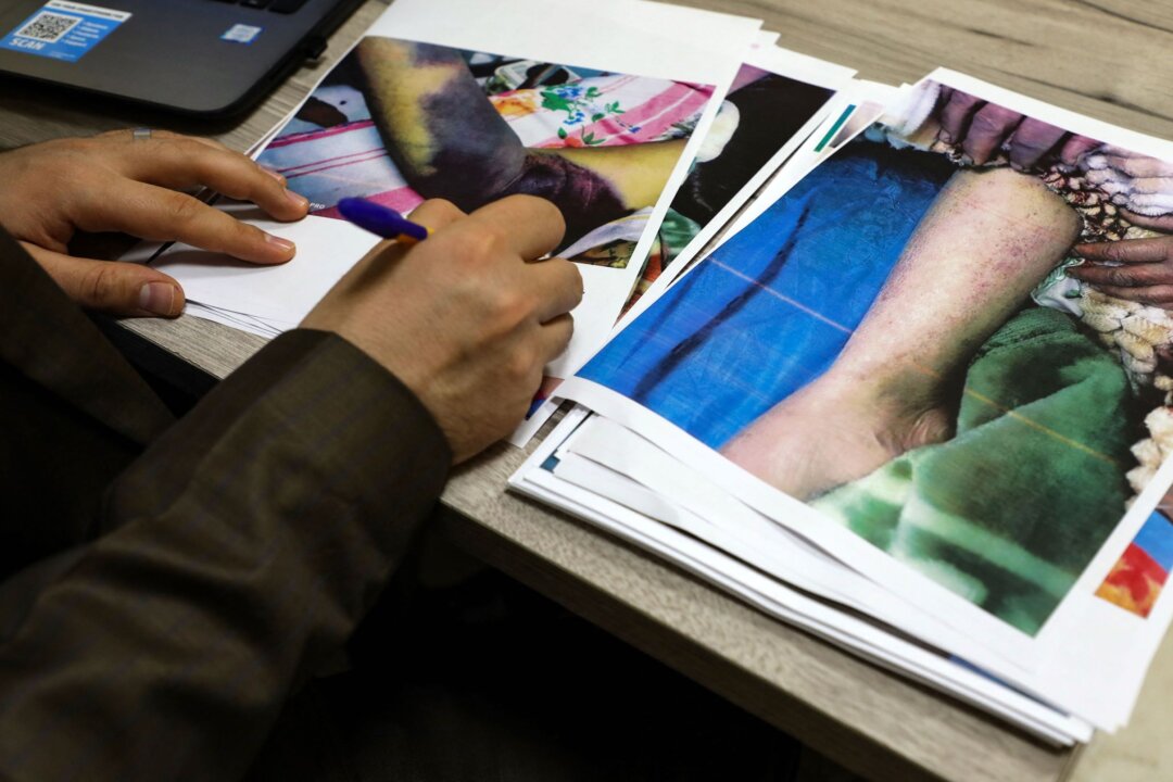 Azhar Assadi, a doctor working with the health department of Iraq's southern Dhi Qar province, examines the files of patients infected by the tick-borne virus Crimean-Congo haemorrhagic fever (CCHF), on May 25, 2022. (Asaad Niazi/AFP via Getty Images)