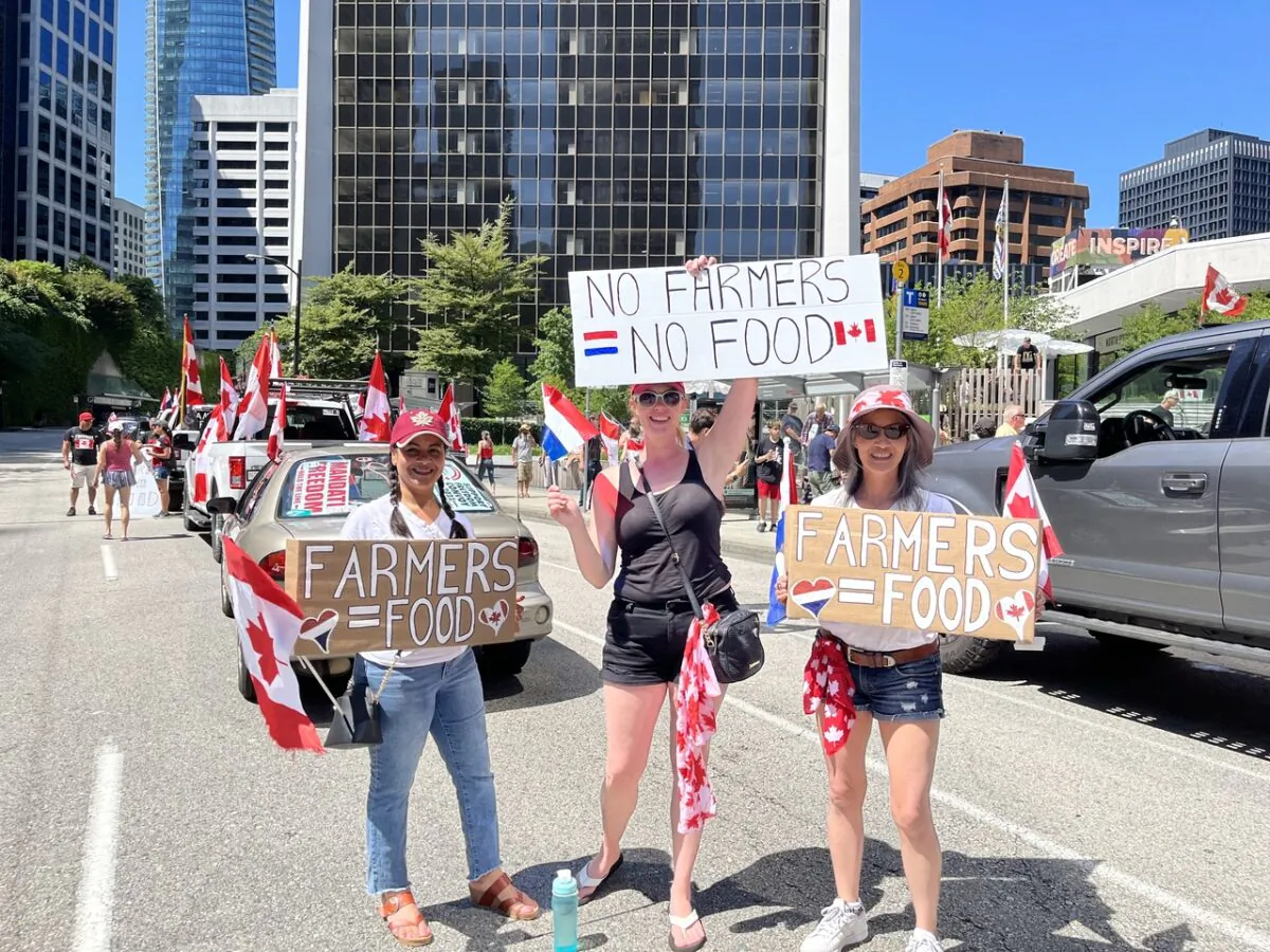 Women holding signs were seen at a convoy protest in Vancouver, B.C., on July 23, 2022, to show support for Dutch farmers protesting the government's climate change policies. (Vivian Yu/The Epoch Times)