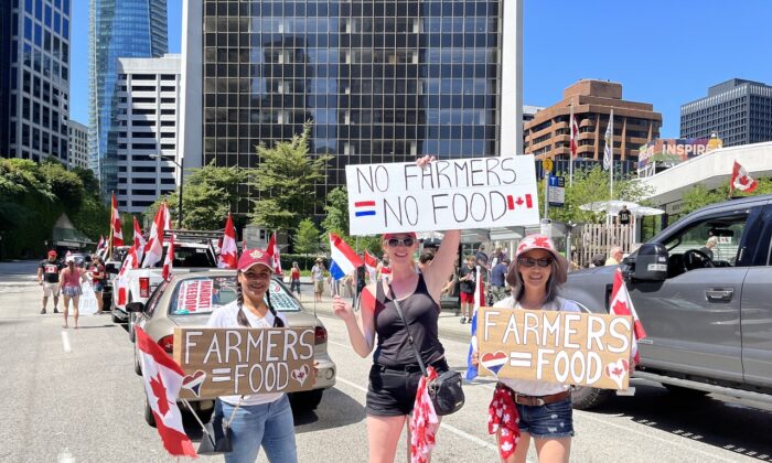 Women holding signs were seen at a convoy protest in Vancouver, B.C., on July 23, 2022, to show support for Dutch farmers protesting the government's climate change policies. (Vivian Yu/The Epoch Times) 