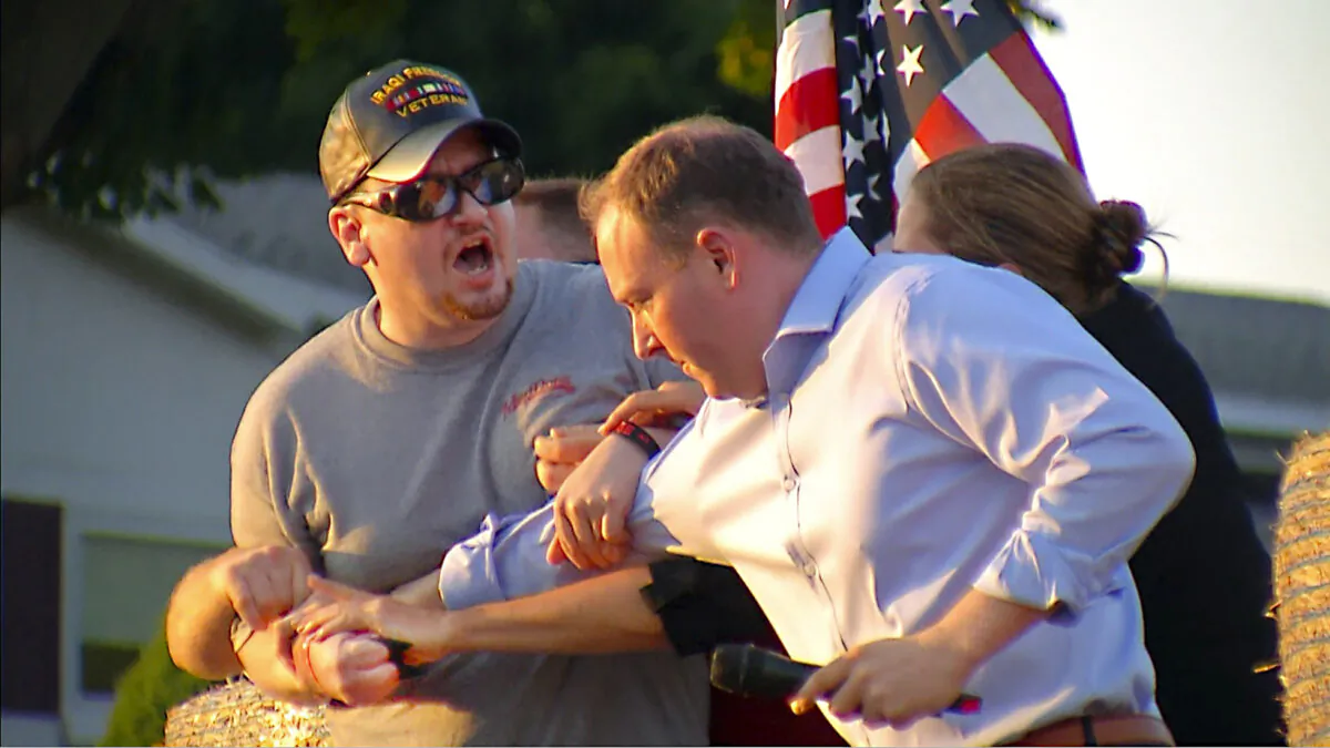 David Jakubonis (L) is subdued as he brandishes a sharp object during an attack on Rep. Lee Zeldin (R-N.Y.) as the Republican candidate for New York governor delivers a speech in Perinton, N.Y., on July 21, 2022, in this image taken from video. (WHEC-TV via AP)