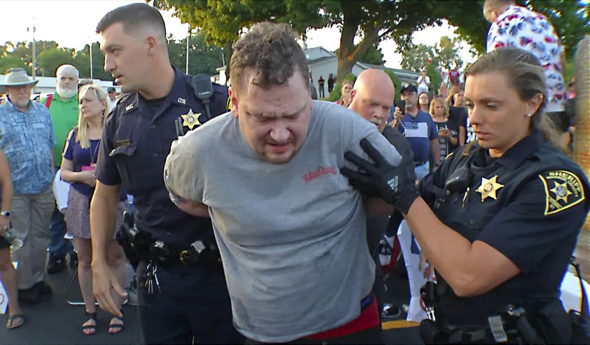 In this image taken from video, David Jakubonis (C) is taken into custody by Monroe County Sheriff deputies after he brandished a sharp object during an attack on Rep. Lee Zeldin (R-N.Y.), as the Republican candidate for New York governor delivered a speech in Perinton, N.Y., on July 21, 2022. (WHEC-TV via AP)