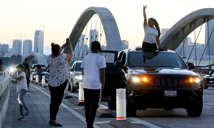 A person poses for a photo  on the newly-opened 6th Street Viaduct, connecting Boyle Heights with downtown L.A., in Los Angeles on July 11, 2022. (Mario Tama/Getty Images)