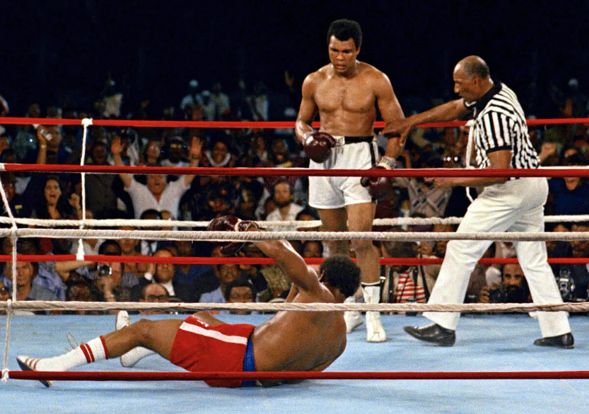 Referee Zack Clayton (R) steps in after challenger Muhammad Ali (C) knocked down defending heavyweight champion George Foreman (L) in the eighth round of their championship bout in Kinshasa, Zaire, Republic of the Congo, on Oct. 30, 1974. (AP Photo)
