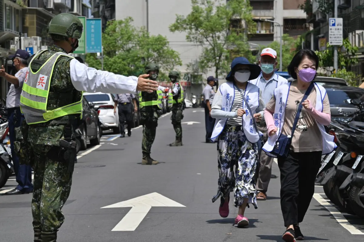 Military personnel guide local residents to take shelter during the Wanan Air Raid Drill, a civilian air-raid drill held on the same day of the annual Han Kuang military exercises, in Taipei on July 25, 2022. (Sam YehAFP via Getty Images)
