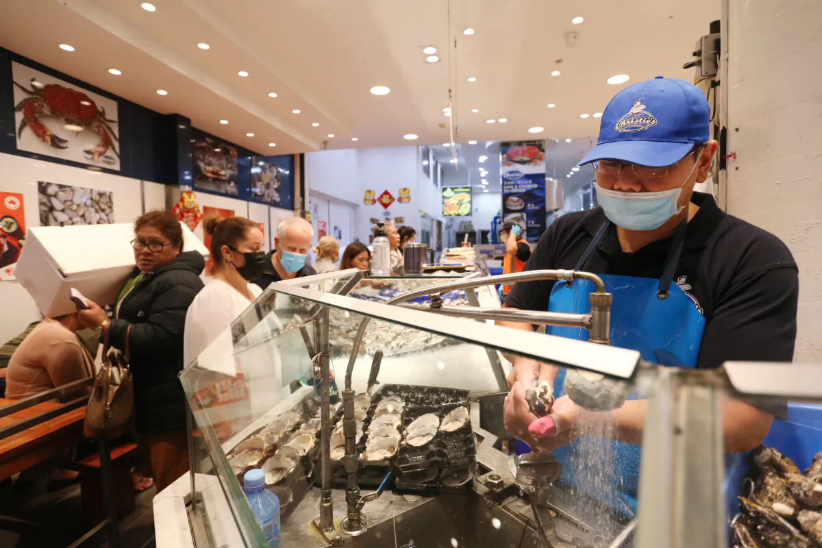 A staff member shucks oysters at the Sydney Fish Market in Sydney, Australia, on April 14, 2022. (Lisa Maree Williams/Getty Images)