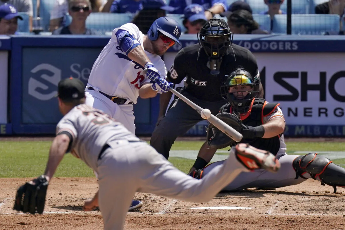 Los Angeles Dodgers' Max Muncy, second from left, hits an RBI double as San Francisco Giants starting pitcher Alex Cobb, left, watches along with catcher Joey Bart, right, and home plate umpire Malachi Moore during the third inning of a baseball game at Dodger Stadium, in Los Angeles, July 24, 2022. (Mark J. Terrill/AP Photo)