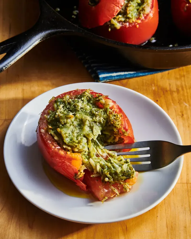 Ripe tomatoes filled with gooey cheese and basil pesto, grilled, and finished with toasted pine nuts. (Joe Lingeman/TNS)